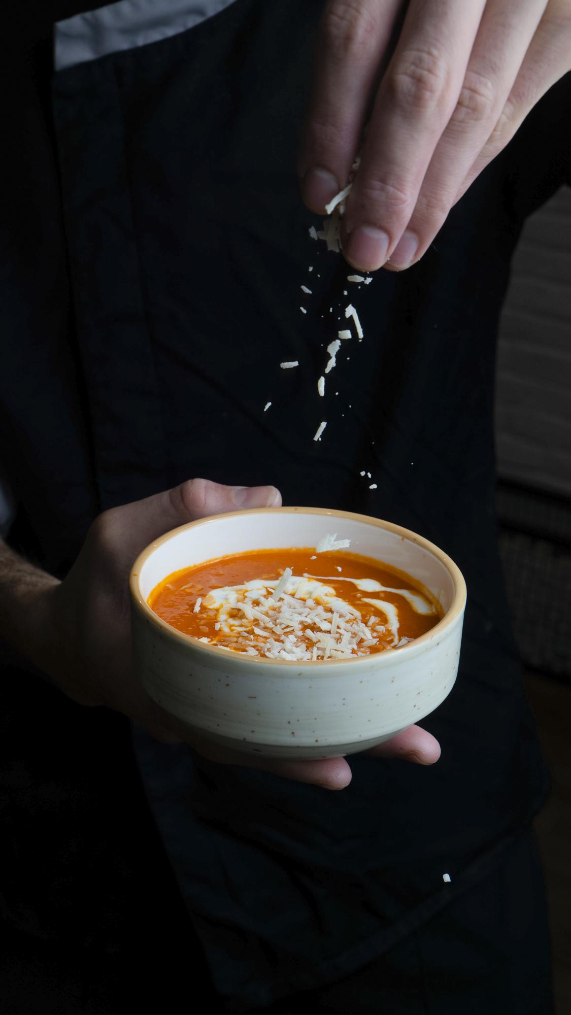 Chef giovane che prepara una zuppa in cucina minimal